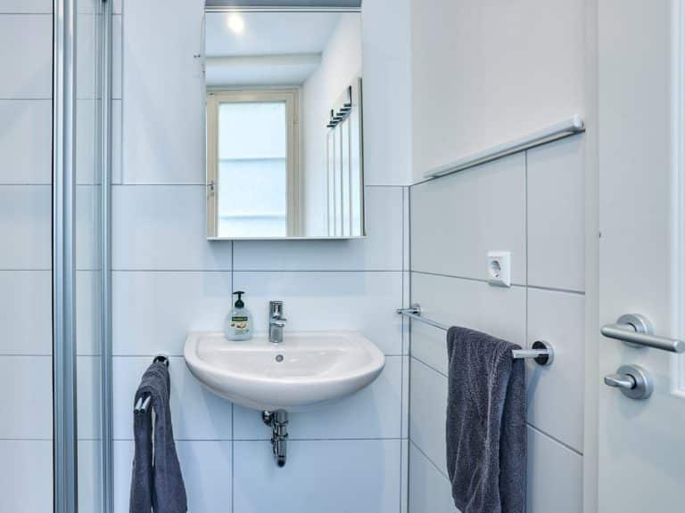 seeglueck | Münsterzauber | zentral 14 Spiegel, Armaturen und frische Handtücher im Badezimmer des Appartements