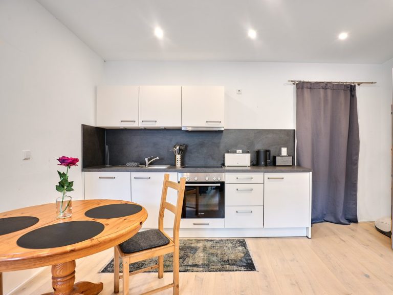 seeglueck | Münsterzauber | zentral 6 Küche mit weißen Fronten und dunkler Arbeitsplatte im Appartement Münsterzauber